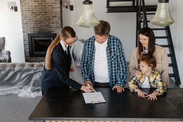 A property manager signing a lease in a house with a family of two adults and one child